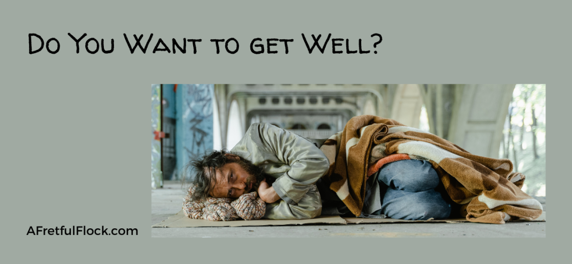 Do you want to get well banner, homeless man lying down
